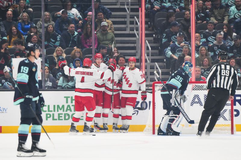 Oct 26, 2024; Seattle, Washington, USA; The Carolina Hurricanes celebrate after a goal scored by right wing Andrei Svechnikov (37) during the first period against the Seattle Kraken at Climate Pledge Arena. Mandatory Credit: Steven Bisig-Imagn Images