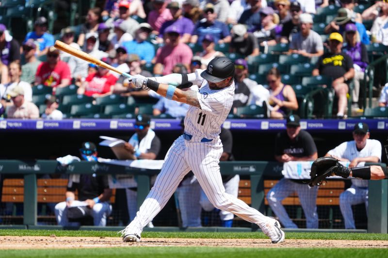 Jun 16, 2024; Denver, Colorado, USA; Colorado Rockies outfielder Jake Cave (11) RBI single in the seventh inning against the Pittsburgh Pirates at Coors Field. Mandatory Credit: Ron Chenoy-USA TODAY Sports