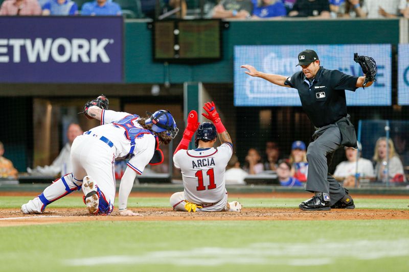 May 15, 2023; Arlington, Texas, USA; Atlanta Braves shortstop Orlando Arcia (11) slides in under a tag by Texas Rangers catcher Jonah Heim (28) during the fifth inning at Globe Life Field. Mandatory Credit: Andrew Dieb-USA TODAY Sports