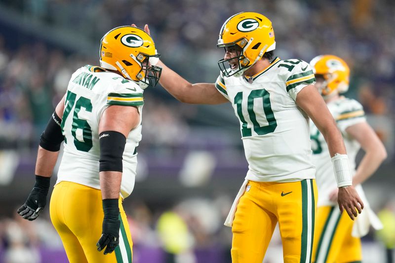 Green Bay Packers' Jordan Love celebrates his touchdown run with Jon Runyan during the first half of an NFL football game against the Minnesota Vikings Sunday, Dec. 31, 2023, in Minneapolis. (AP Photo/Abbie Parr)