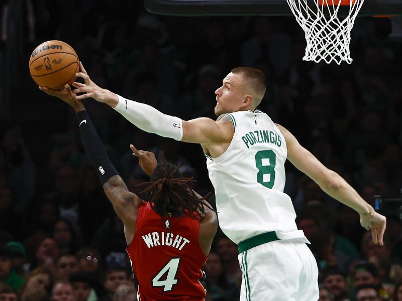 BOSTON, MA - APRIL 21: Kristaps Porzingis #8 of the Boston Celtics blocks a shot by Delon Wright #4 of the Miami Heat during the second half of game one of the Eastern Conference First Round Playoffs at TD Garden on April 21, 2024 in Boston, Massachusetts. NOTE TO USER: User expressly acknowledges and agrees that, by downloading and/or using this Photograph, user is consenting to the terms and conditions of the Getty Images License Agreement. (Photo By Winslow Townson/Getty Images)