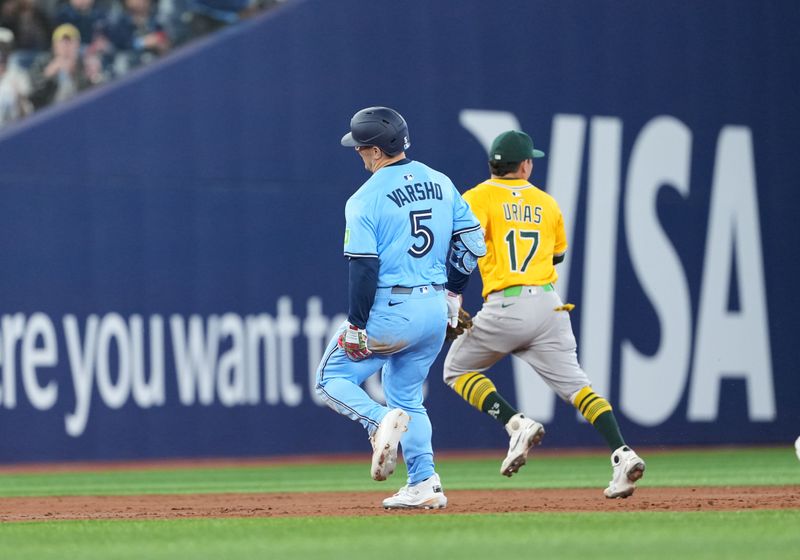 May 31, 2025; Toronto, Ontario, CAN; Toronto Blue Jays centre fielder Daulton Varsho (5) grabs his left leg after rounding second base against the Athletics during the third inning at Rogers Centre. Mandatory Credit: Nick Turchiaro-Imagn Images