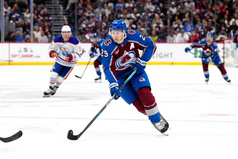 Nov 30, 2024; Denver, Colorado, USA; Colorado Avalanche center Nathan MacKinnon (29) controls the puck in the second period against the Edmonton Oilers at Ball Arena. Mandatory Credit: Ron Chenoy-Imagn Images