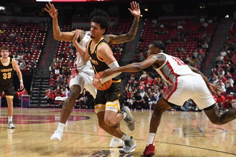 Feb 3, 2024; Las Vegas, Nevada, USA; Wyoming Cowboys guard Brendan Wenzel (1) drives by UNLV Rebels forward Isaiah Cottrell (0) and Luis Rodriguez (15) at Thomas & Mack Center. Mandatory Credit: Candice Ward-USA TODAY Sports