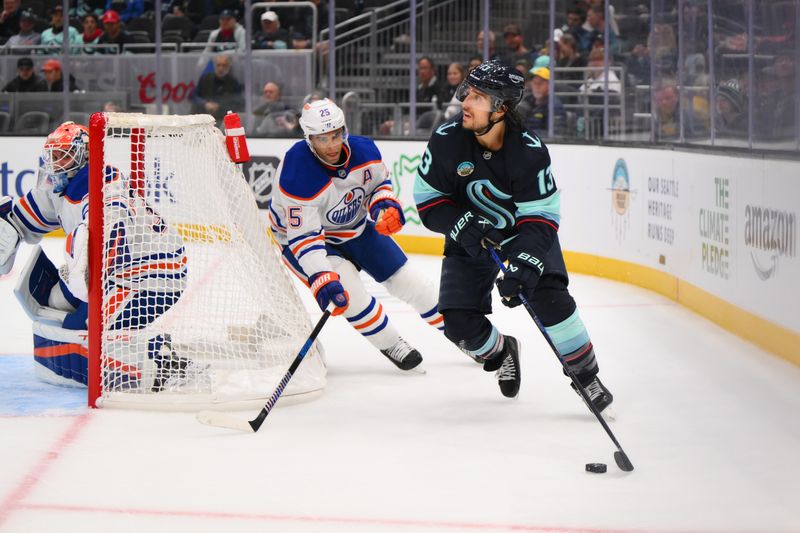 Oct 2, 2024; Seattle, Washington, USA; Seattle Kraken left wing Brandon Tanev (13) plays the puck while defended by Edmonton Oilers defenseman Darnell Nurse (25) during the third period at Climate Pledge Arena. Mandatory Credit: Steven Bisig-Imagn Images