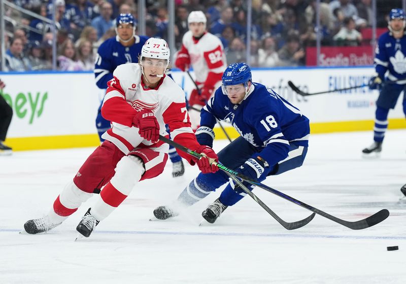 Oct 2, 2025; Toronto, Ontario, CAN; Detroit Red Wings defenseman Simon Edvinsson (77) battles for the puck with Toronto Maple Leafs center Steven Lorentz (18) during the third period at Scotiabank Arena. Mandatory Credit: Nick Turchiaro-Imagn Images