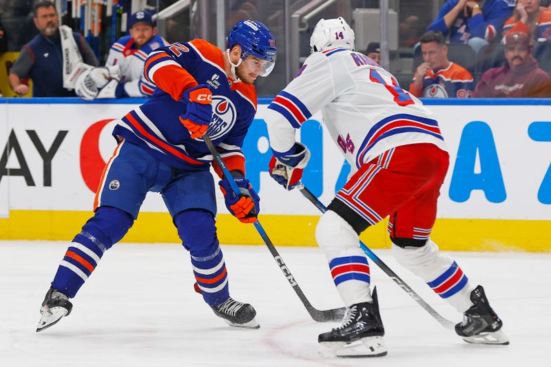 Oct 30, 2025; Edmonton, Alberta, CAN; New York Rangers forward Taylor Raddysh (14) tries to block a shot by Edmonton Oilers forward Vasily Podkolzin (92) during the third period at Rogers Place. Mandatory Credit: Perry Nelson-Imagn Images