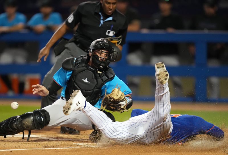 Feb 25, 2023; Port St. Lucie, Florida, USA;  New York Mets third baseman Eduardo Escobar (10) dives into home plate and scores a run as Miami Marlins catcher Nick Fortes (4) drops the ball on the play in the second inning at Clover Park. Mandatory Credit: Jim Rassol-USA TODAY Sports