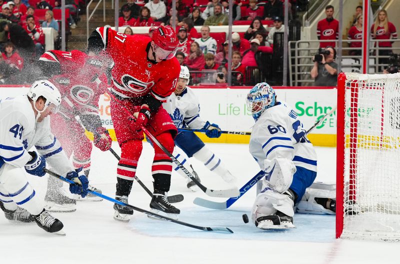 Apr 13, 2025; Raleigh, North Carolina, USA;  Toronto Maple Leafs goaltender Joseph Woll (60) stops the scoring attempt by Carolina Hurricanes right wing Andrei Svechnikov (37) during the first period at Lenovo Center. Mandatory Credit: James Guillory-Imagn Images