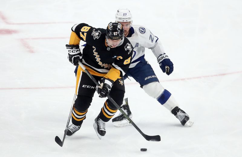 Nov 19, 2024; Pittsburgh, Pennsylvania, USA;  Pittsburgh Penguins center Sidney Crosby (87) skates with the puck as Tampa Bay Lightning defenseman Ryan McDonagh (27) chases during the second period at PPG Paints Arena. Mandatory Credit: Charles LeClaire-Imagn Images