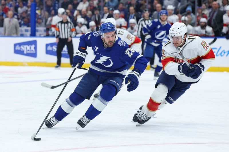 Dec 15, 2025; Tampa, Florida, USA; Tampa Bay Lightning center Zemgus Girgensons (28) controls the puck from Florida Panthers right wing Mackie Samoskevich (11) in the first period at Benchmark International Arena. Mandatory Credit: Nathan Ray Seebeck-Imagn Images
