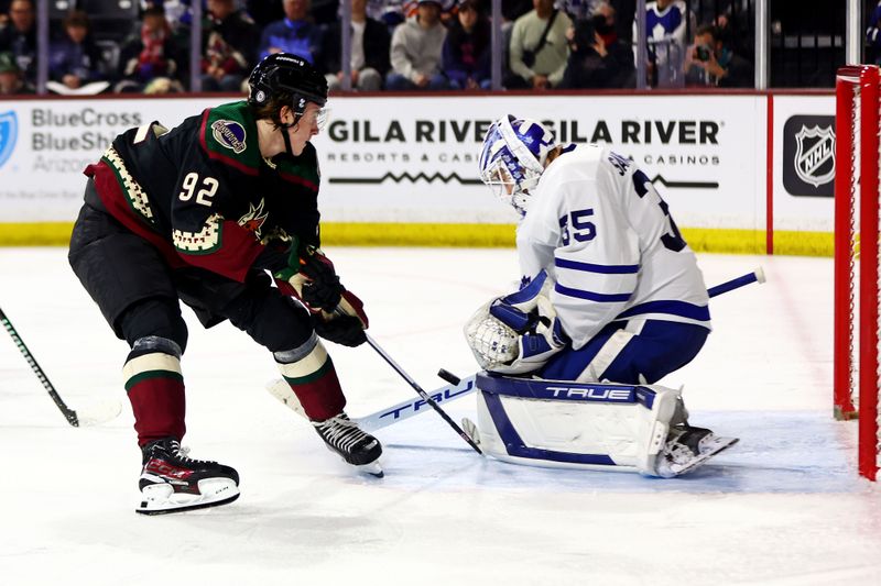 Feb 21, 2024; Tempe, Arizona, USA; Arizona Coyotes center Logan Cooley (92) shoots the puck against Toronto Maple Leafs goaltender Ilya Samsonov (35) during the second period at Mullett Arena. Mandatory Credit: Mark J. Rebilas-USA TODAY Sports