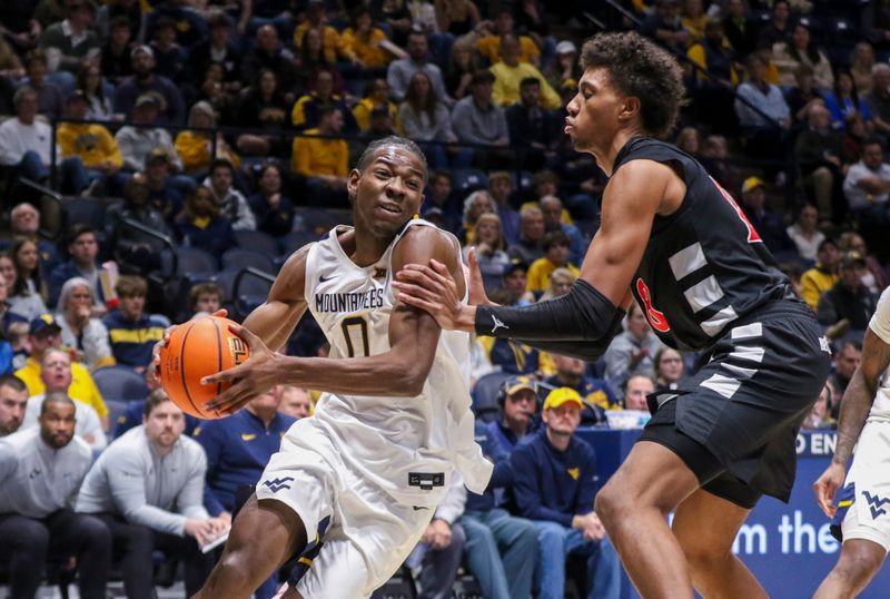 Jan 6, 2026; Morgantown, West Virginia, USA; West Virginia Mountaineers forward Brenen Lorient (0) drives the baseline against Cincinnati Bearcats forward Baba Miller (18) during the second half at Hope Coliseum. Mandatory Credit: Ben Queen-Imagn Images