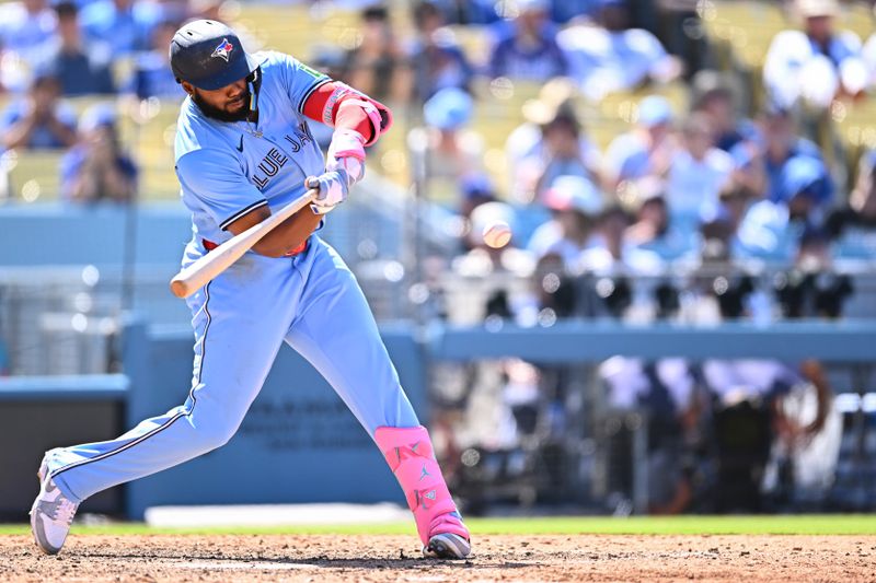 Aug 10, 2025; Los Angeles, California, USA; Toronto Blue Jays first baseman Vladimir Guerrero Jr. (27) hits a solo home run against the Los Angeles Dodgers during the eighth inning at Dodger Stadium. Mandatory Credit: Jonathan Hui-Imagn Images