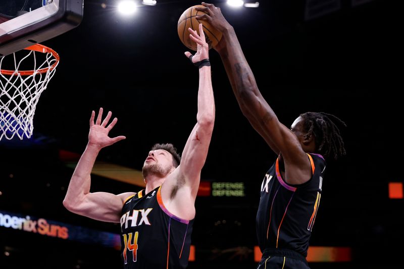 PHOENIX, ARIZONA - APRIL 03: Drew Eubanks #14 and Bol Bol #11 of the Phoenix Suns control a rebound during the first half against the Cleveland Cavaliers at Footprint Center on April 03, 2024 in Phoenix, Arizona. NOTE TO USER: User expressly acknowledges and agrees that, by downloading and or using this photograph, User is consenting to the terms and conditions of the Getty Images License Agreement.  (Photo by Chris Coduto/Getty Images)