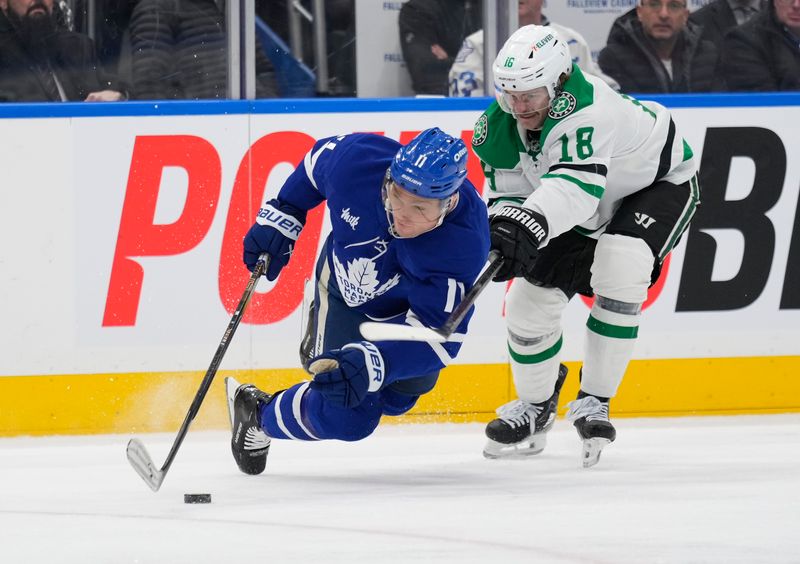 Jan 14, 2025; Toronto, Ontario, CAN; Toronto Maple Leafs forward Max Domi (11) gets tripped by Dallas Stars forward Sam Steel (18) as he carries the puck during the first period at Scotiabank Arena. Mandatory Credit: John E. Sokolowski-Imagn Images