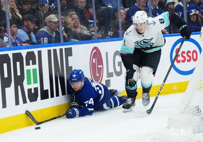 Oct 18, 2025; Toronto, Ontario, CAN; Toronto Maple Leafs center Bobby McMann (74) go after the puck against Seattle Kraken defenseman Cale Fleury (8) during the third period at Scotiabank Arena. Mandatory Credit: Nick Turchiaro-Imagn Images