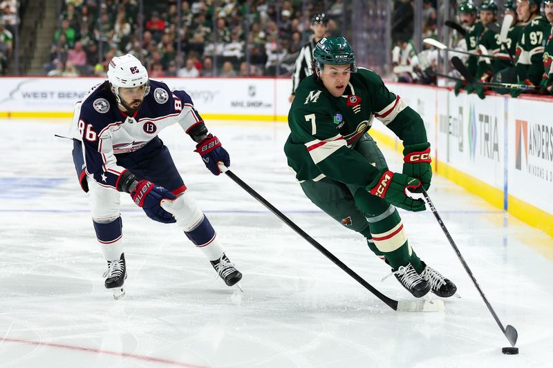 Oct 10, 2024; Saint Paul, Minnesota, USA; Minnesota Wild defenseman Brock Faber (7) skates with the puck as Columbus Blue Jackets right wing Kirill Marchenko (86) defends during the second period at Xcel Energy Center. Mandatory Credit: Matt Krohn-Imagn Images