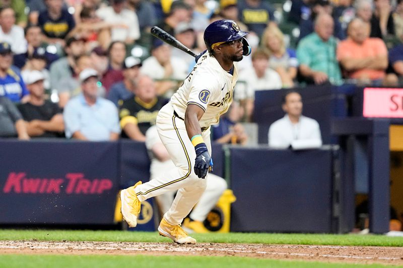 Jul 10, 2024; Milwaukee, Wisconsin, USA;  Milwaukee Brewers third baseman Andruw Monasterio (14) hits an RBI single during the seventh inning against the Pittsburgh Pirates at American Family Field. Mandatory Credit: Jeff Hanisch-USA TODAY Sports