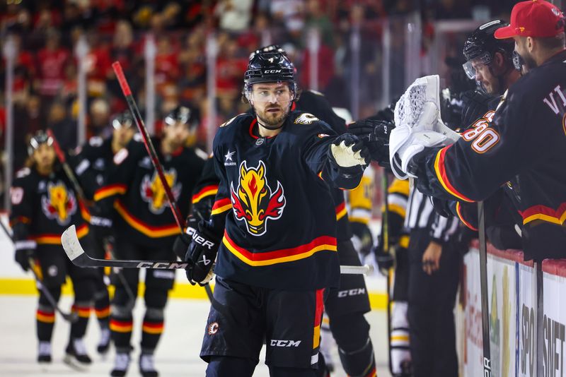 Oct 22, 2024; Calgary, Alberta, CAN; Calgary Flames defenseman Rasmus Andersson (4) celebrates his goal with teammates against the Pittsburgh Penguins during the first period at Scotiabank Saddledome. Mandatory Credit: Sergei Belski-Imagn Images