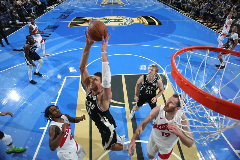 MILWAUKEE, WI - NOVEMBER 12: Brook Lopez #11 of the Milwaukee Bucks grabs the rebound during the game against the Toronto Raptors   during the Emirates NBA Cup game on November 12, 2024 at Fiserv Forum Center in Milwaukee, Wisconsin. NOTE TO USER: User expressly acknowledges and agrees that, by downloading and or using this Photograph, user is consenting to the terms and conditions of the Getty Images License Agreement. Mandatory Copyright Notice: Copyright 2024 NBAE (Photo by Gary Dineen/NBAE via Getty Images).