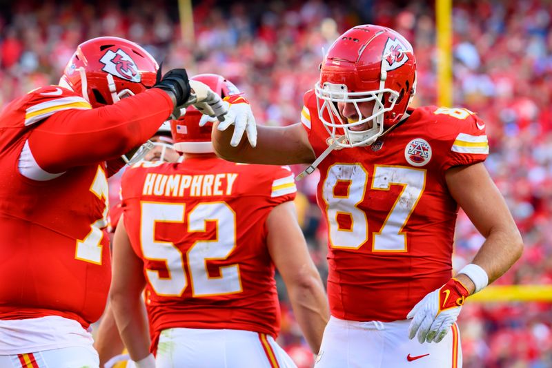 Kansas City Chiefs tight end Travis Kelce (87) and Kansas City Chiefs offensive tackle Donovan Smith, right, celebrate Kelce's touchdown against the Los Angeles Chargers during the first half of an NFL football game, Sunday, Oct. 22, 2023 in Kansas City, Mo. (AP Photo/Reed Hoffmann)