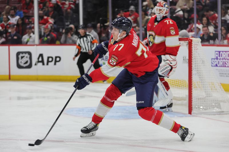 Oct 17, 2024; Sunrise, Florida, USA; Florida Panthers defenseman Niko Mikkola (77) moves the puck against the Vancouver Canucks during the second period at Amerant Bank Arena. Mandatory Credit: Sam Navarro-Imagn Images