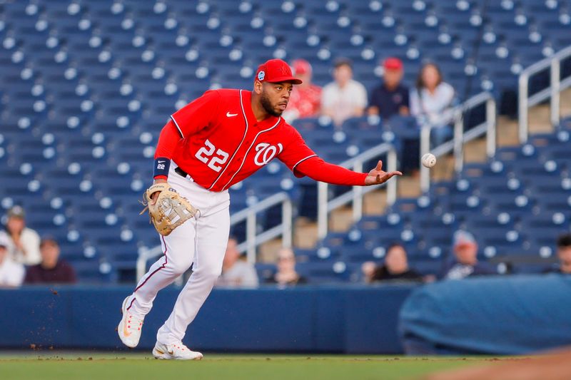 Mar 16, 2023; West Palm Beach, Florida, USA; Washington Nationals first baseman Dominic Smith (22) flips the baseball to starting pitcher Willy Peralta (not pictured) for an out during the second inning at The Ballpark of the Palm Beaches. Mandatory Credit: Sam Navarro-USA TODAY Sports