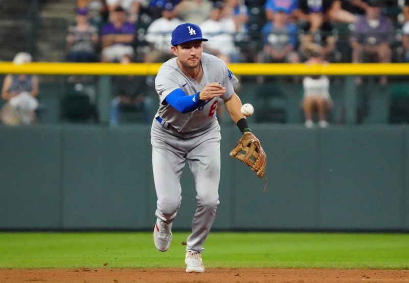 Jul 30, 2022; Denver, Colorado, USA; Los Angeles Dodgers shortstop Trea Turner (6) tosses the ball against the Colorado Rockies in the sixth inning at Coors Field. Mandatory Credit: Ron Chenoy-USA TODAY Sports