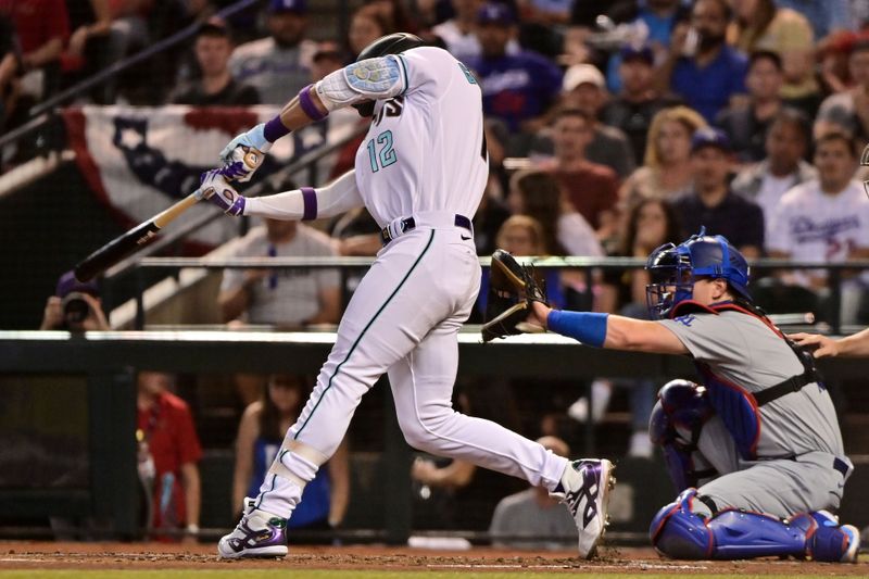 Oct 11, 2023; Phoenix, Arizona, USA; Arizona Diamondbacks left fielder Lourdes Gurriel Jr. (12) hits a single against the Los Angeles Dodgers in the second inning for game three of the NLDS for the 2023 MLB playoffs at Chase Field. Mandatory Credit: Matt Kartozian-USA TODAY Sports