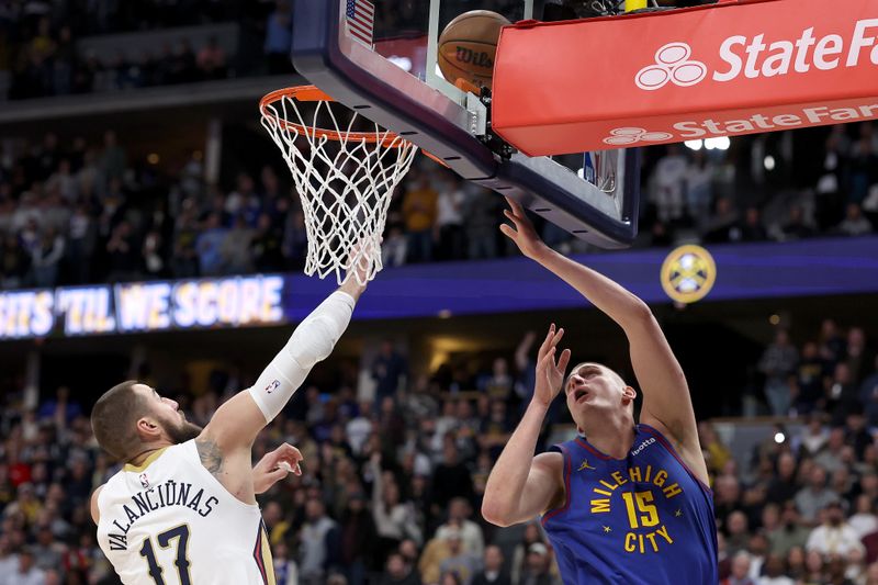 DENVER, COLORADO - JANUARY 12: Nikola Jokic #15 of the Denver Nuggets goes to the basket against Jonas Valanciunas #17 of the New Orleans Pelicans in the first quarter at Ball Arena on January 12, 2024 in Denver, Colorado. NOTE TO USER: User expressly acknowledges and agrees that, by downloading and or using this photograph, User is consenting to the terms and conditions of the Getty Images License Agreement.  (Photo by Matthew Stockman/Getty Images)