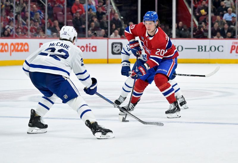 Apr 6, 2024; Montreal, Quebec, CAN; Montreal Canadiens forward Juraj Slafkovsky (20) plays the puck and Toronto Maple Leafs defenseman Jake McCabe (22) defends during the third period at the Bell Centre. Mandatory Credit: Eric Bolte-USA TODAY Sports