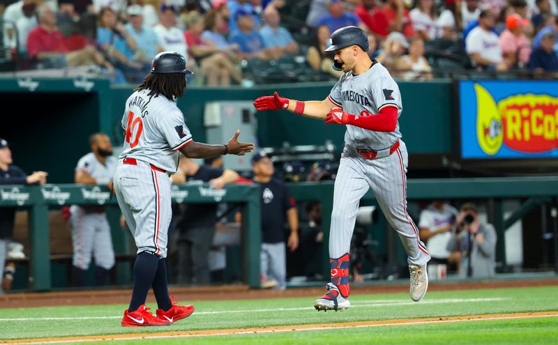 Aug 17, 2024; Arlington, Texas, USA;  Minnesota Twins left fielder Trevor Larnach (9) hits a home run and celebrates with Minnesota Twins third base coach/outfield coach Tommy Watkins (40) during the fourth inning against the Texas Rangers at Globe Life Field. Mandatory Credit: Kevin Jairaj-USA TODAY Sports