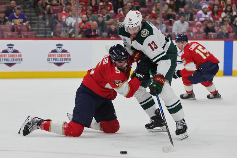 Oct 22, 2024; Sunrise, Florida, USA; Florida Panthers defenseman Aaron Ekblad (5) defends against Minnesota Wild center Yakov Trenin (13) during the first period at Amerant Bank Arena. Mandatory Credit: Sam Navarro-Imagn Images