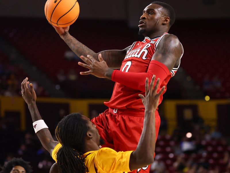 Feb 28, 2026; Tempe, Arizona, USA; Utah Utes forward Seydou Traore (0) drives to the basket against Arizona State Sun Devils guard Anthony Johnson (2) in the first half at Desert Financial Arena. Mandatory Credit: Mark J. Rebilas-Imagn Images