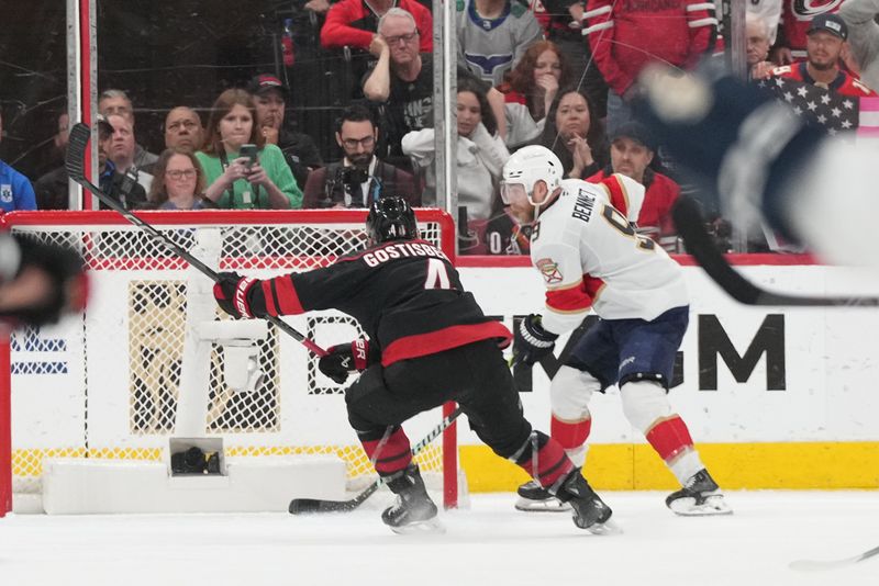 May 28, 2025; Raleigh, North Carolina, USA; Florida Panthers forward Sam Bennett (9) scores an empty net goal against Carolina Hurricanes defenseman Shayne Gostibehere (4) during the third period in game five of the Eastern Conference Final of the 2025 Stanley Cup Playoffs at Lenovo Center. Mandatory Credit: James Guillory-Imagn Images