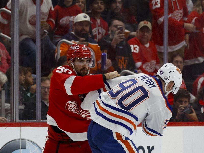 Oct 27, 2024; Detroit, Michigan, USA; Detroit Red Wings center Joe Veleno (90) fights with Edmonton Oilers right wing Corey Perry (90) during the first period of the game at Little Caesars Arena. Mandatory Credit: Brian Bradshaw Sevald-Imagn Images