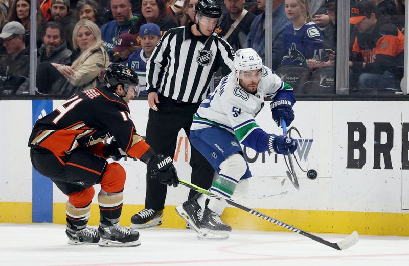 Mar 3, 2024; Anaheim, California, USA; Vancouver Canucks defenseman Mark Friedman (51) passes against Anaheim Ducks center Adam Henrique (14) during the first period at Honda Center. Mandatory Credit: Jason Parkhurst-USA TODAY Sports