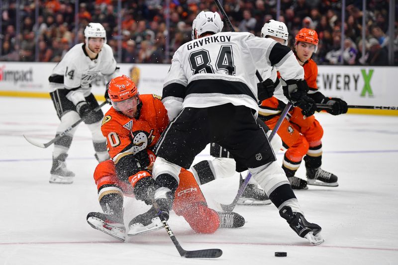 Nov 29, 2024; Anaheim, California, USA; Los Angeles Kings defenseman Vladislav Gavrikov (84) hits Anaheim Ducks right wing Brett Leason (20) while playing for the puck during the second period at Honda Center. Mandatory Credit: Gary A. Vasquez-Imagn Images