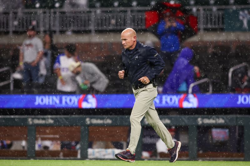 Apr 10, 2025; Atlanta, Georgia, USA; Atlanta Braves vice president of the grounds crew Ed Mangan runs on the field during a rain delay against the Philadelphia Phillies in the seventh inning at Truist Park. Mandatory Credit: Brett Davis-Imagn Images

