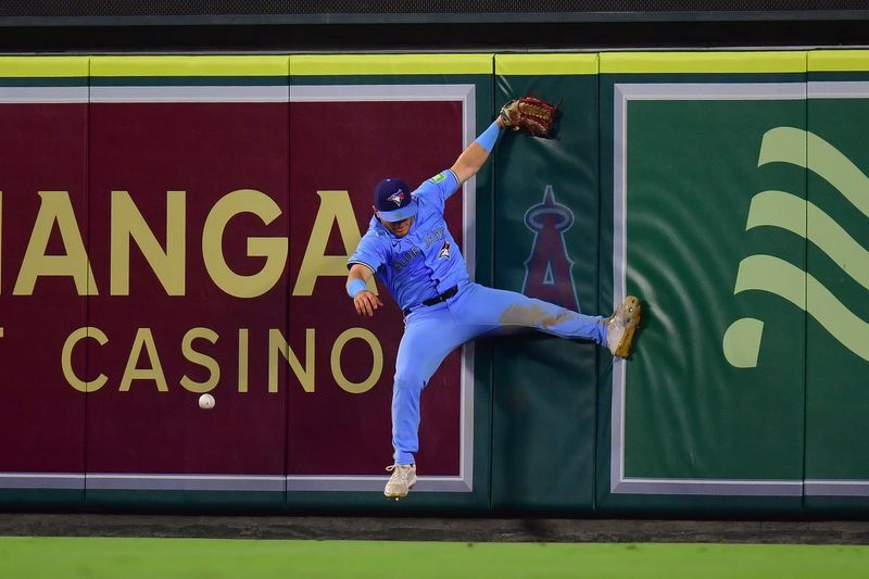 Aug 13, 2024; Anaheim, California, USA; Toronto Blue Jays center fielder Daulton Varsho (25) misses catching the home run of Los Angeles Angels designated hitter Willie Calhoun (5) during the ninth inning at Angel Stadium. Mandatory Credit: Gary A. Vasquez-USA TODAY Sports