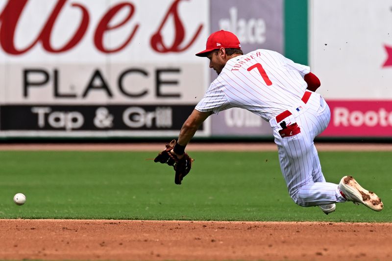 Mar 18, 2024; Clearwater, Florida, USA; Philadelphia Phillies shortstop Trea Turner (7) attempts to field a ground ball in the third  inning of the spring training game against the Pittsburgh Pirates at BayCare Ballpark. Mandatory Credit: Jonathan Dyer-USA TODAY Sports