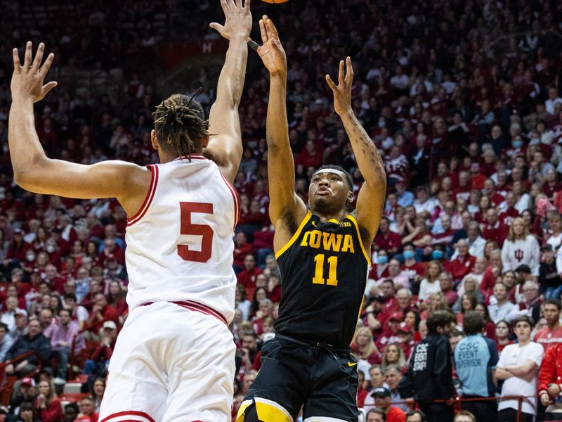 Feb 28, 2023; Bloomington, Indiana, USA; Iowa Hawkeyes guard Tony Perkins (11) shoots the ball while Indiana Hoosiers forward Malik Reneau (5) defends in the second half at Simon Skjodt Assembly Hall. Mandatory Credit: Trevor Ruszkowski-USA TODAY Sports