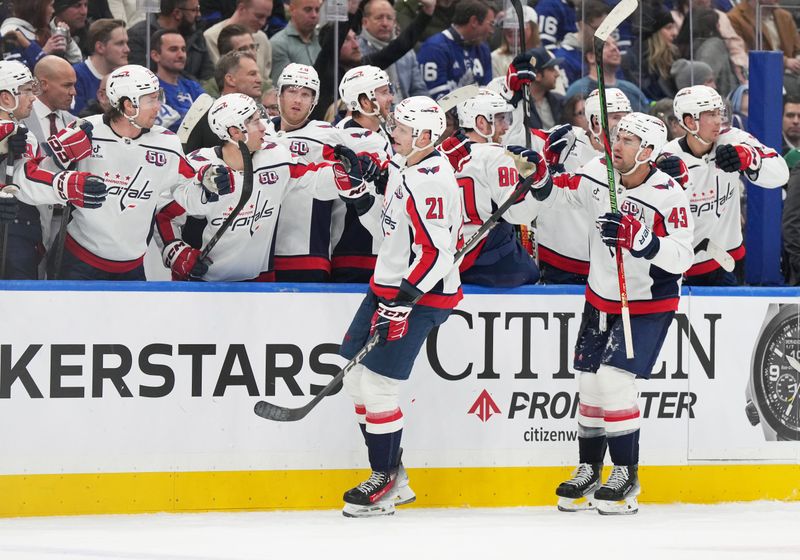 Dec 6, 2024; Toronto, Ontario, CAN; Washington Capitals center Aliaksei Protas (21) celebrates scoring an empty net goal against the Toronto Maple Leafs during the third period at Scotiabank Arena. Mandatory Credit: Nick Turchiaro-Imagn Images