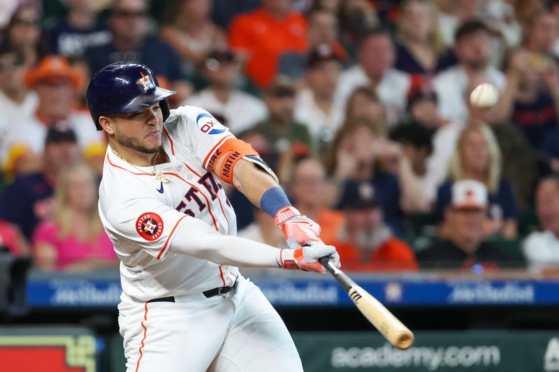 Jun 23, 2024; Houston, Texas, USA; Houston Astros designated hitter Yainer Diaz (21) hits a RBI sacrifice against the Baltimore Orioles in the fourth inning at Minute Maid Park. Mandatory Credit: Thomas Shea-USA TODAY Sports