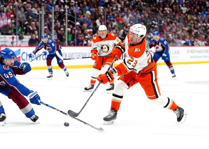 Oct 18, 2024; Denver, Colorado, USA; Anaheim Ducks center Mason McTavish (23) shoots the puck at Colorado Avalanche defenseman Samuel Girard (49) in the first period at Ball Arena. Mandatory Credit: Ron Chenoy-Imagn Images