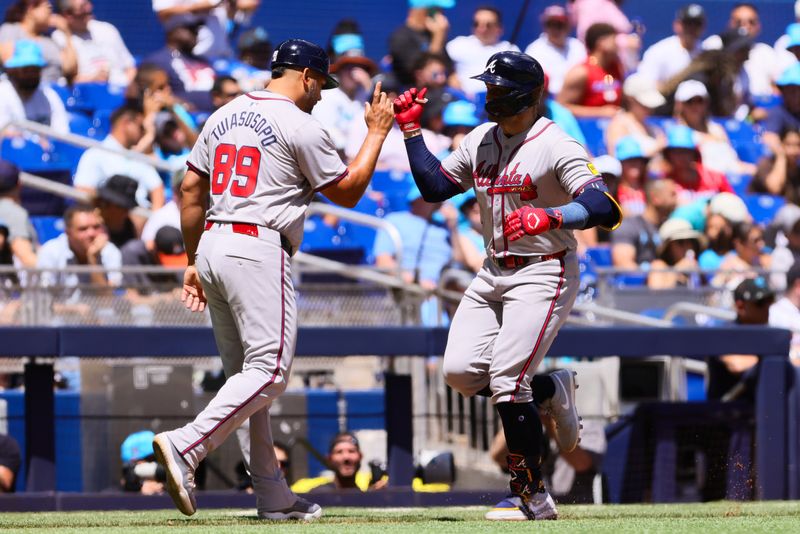 Apr 14, 2024; Miami, Florida, USA; Atlanta Braves left fielder Adam Duvall (14) celebrates with third base coach Matt Tuiasosopo (89) after hitting a home run against the Miami Marlins during the fourth inning at loanDepot Park. Mandatory Credit: Sam Navarro-USA TODAY Sports