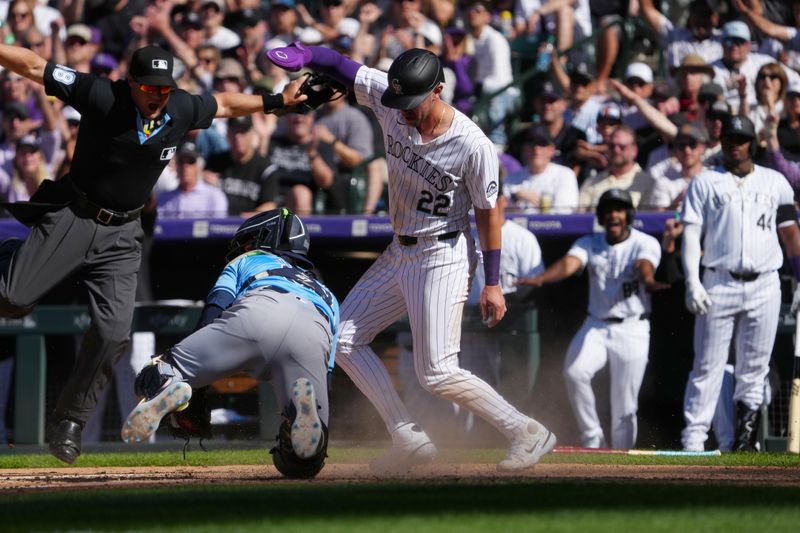 Apr 5, 2024; Denver, Colorado, USA; Colorado Rockies outfielder Nolan Jones (22) scores a run past Tampa Bay Rays catcher Ben Rortvedt (30) in the eighth inning at Coors Field. Mandatory Credit: Ron Chenoy-USA TODAY Sports