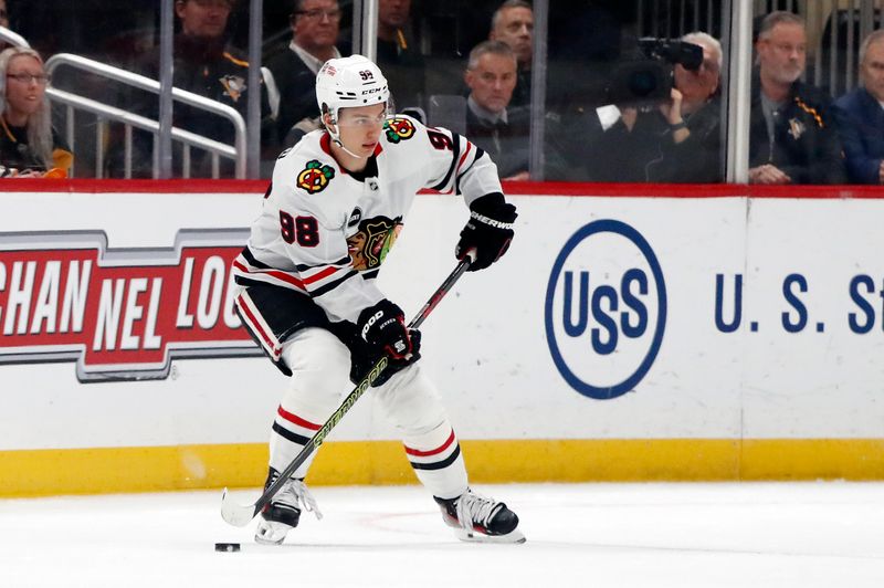 Oct 10, 2023; Pittsburgh, Pennsylvania, USA; Chicago Blackhawks center Connor Bedard (98) handles the puck against the Pittsburgh Penguins during the first period at the PPG Paints Arena. Bedard is making his NHL debut. Mandatory Credit: Charles LeClaire-USA TODAY Sports