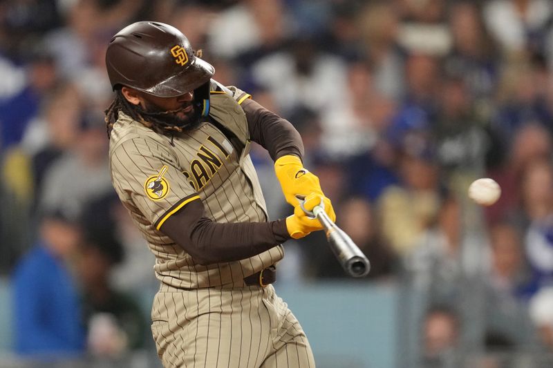 Sep 25, 2024; Los Angeles, California, USA;  San Diego Padres right fielder Fernando Tatis Jr. (23) hits a home run in the fifth inning against the Los Angeles Dodgers at Dodger Stadium. Mandatory Credit: Kirby Lee-Imagn Images